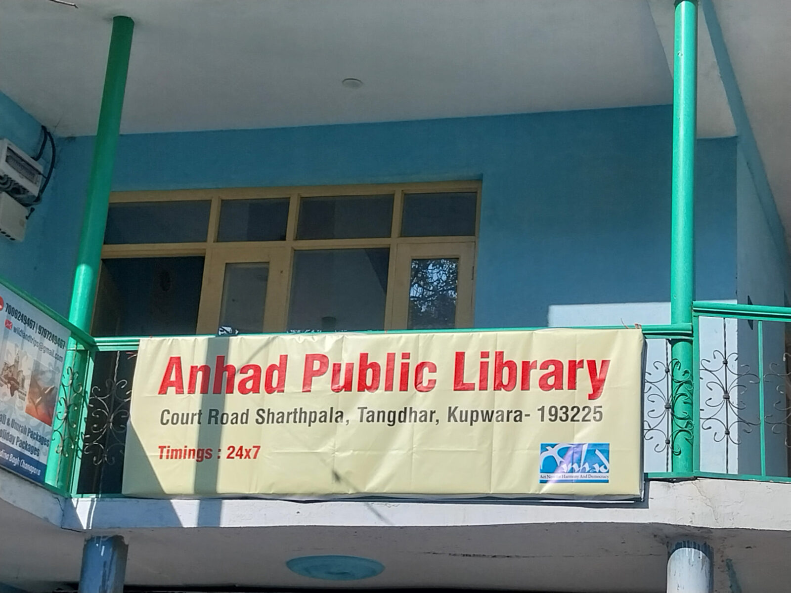 The Anhad Public Library signboard at Court Road, Sharthpala, Tangdhar, showing 24x7 timings