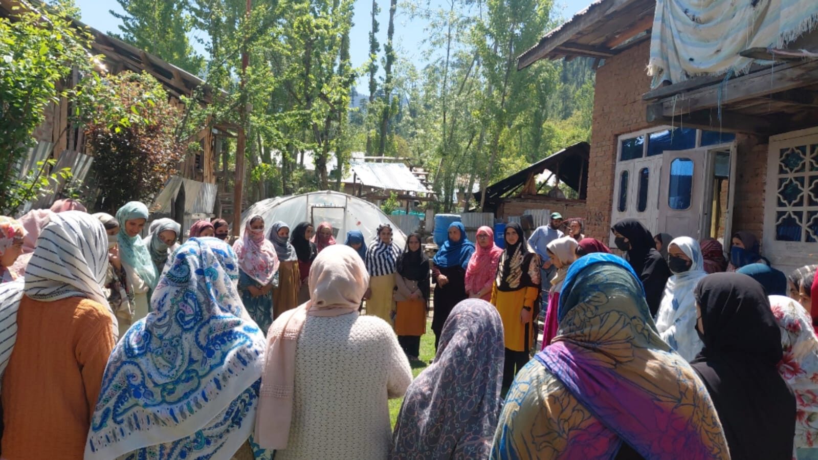 Village women standing together in a courtyard during an outreach visit
