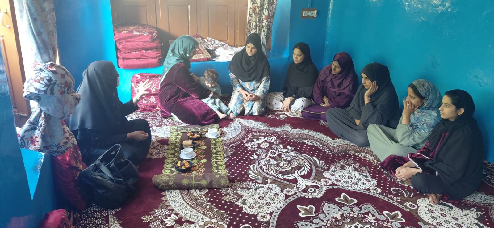 A small indoor group meeting with women seated together over tea